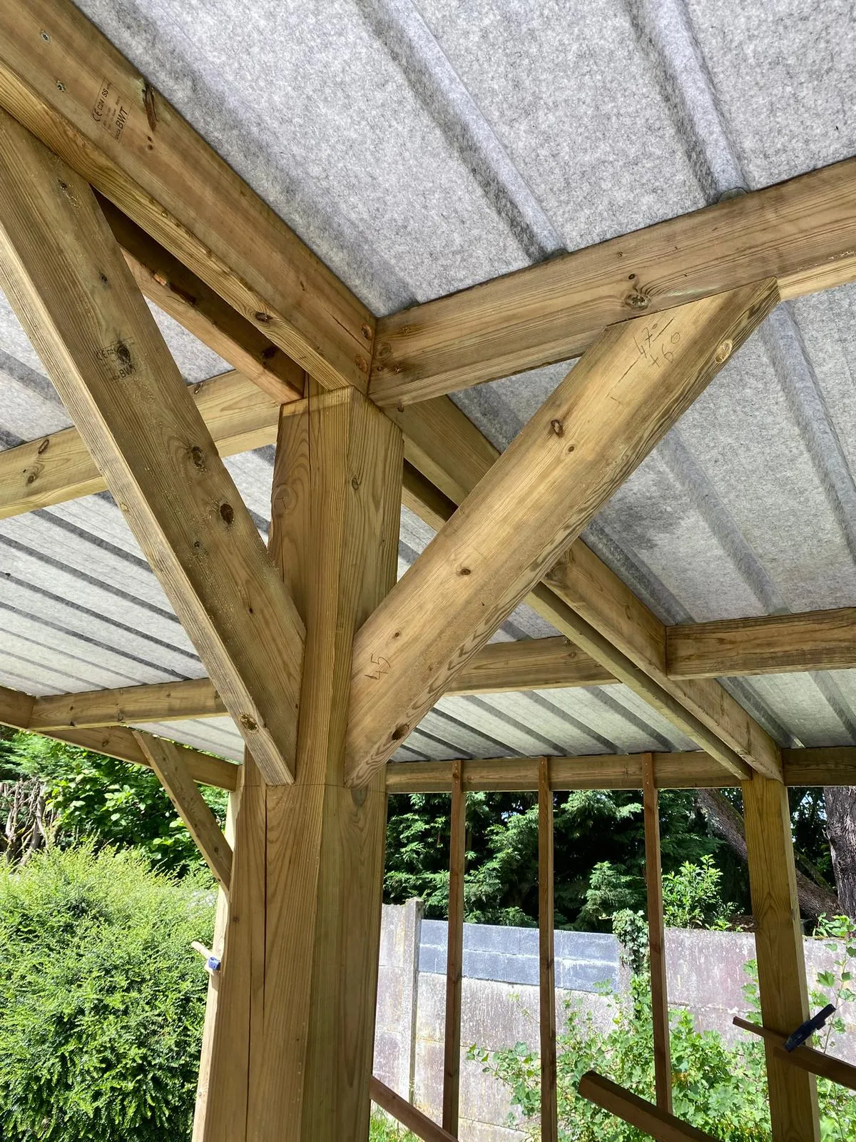 Détail d'un assemblage bois entre poteau et charpente d'un carport, dans l'Aisne