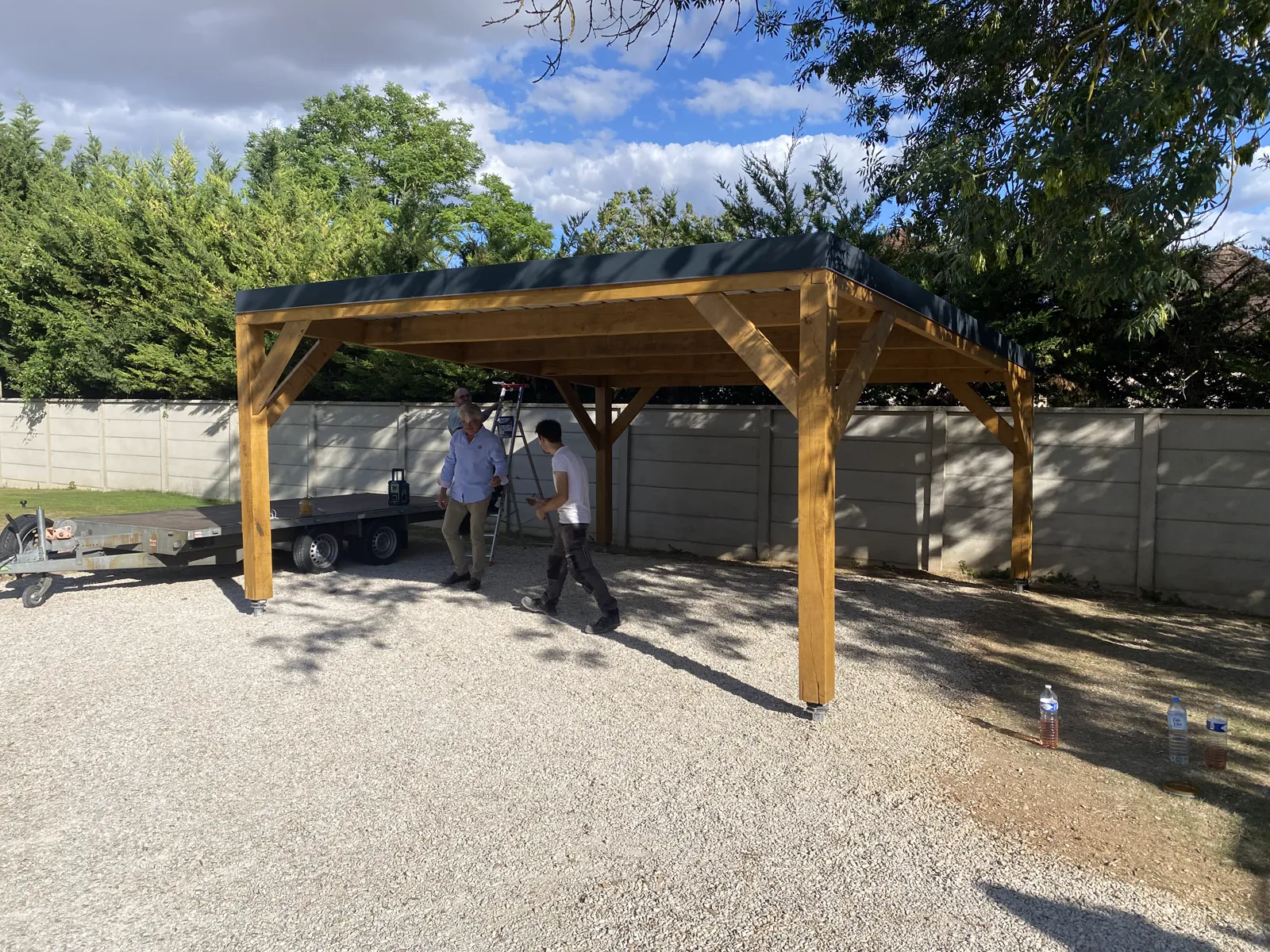 Carport en chêne autoporté vu de trois quarts avec gouttières aluminium noir, à Pont-Sainte-Marie dans l'Aube