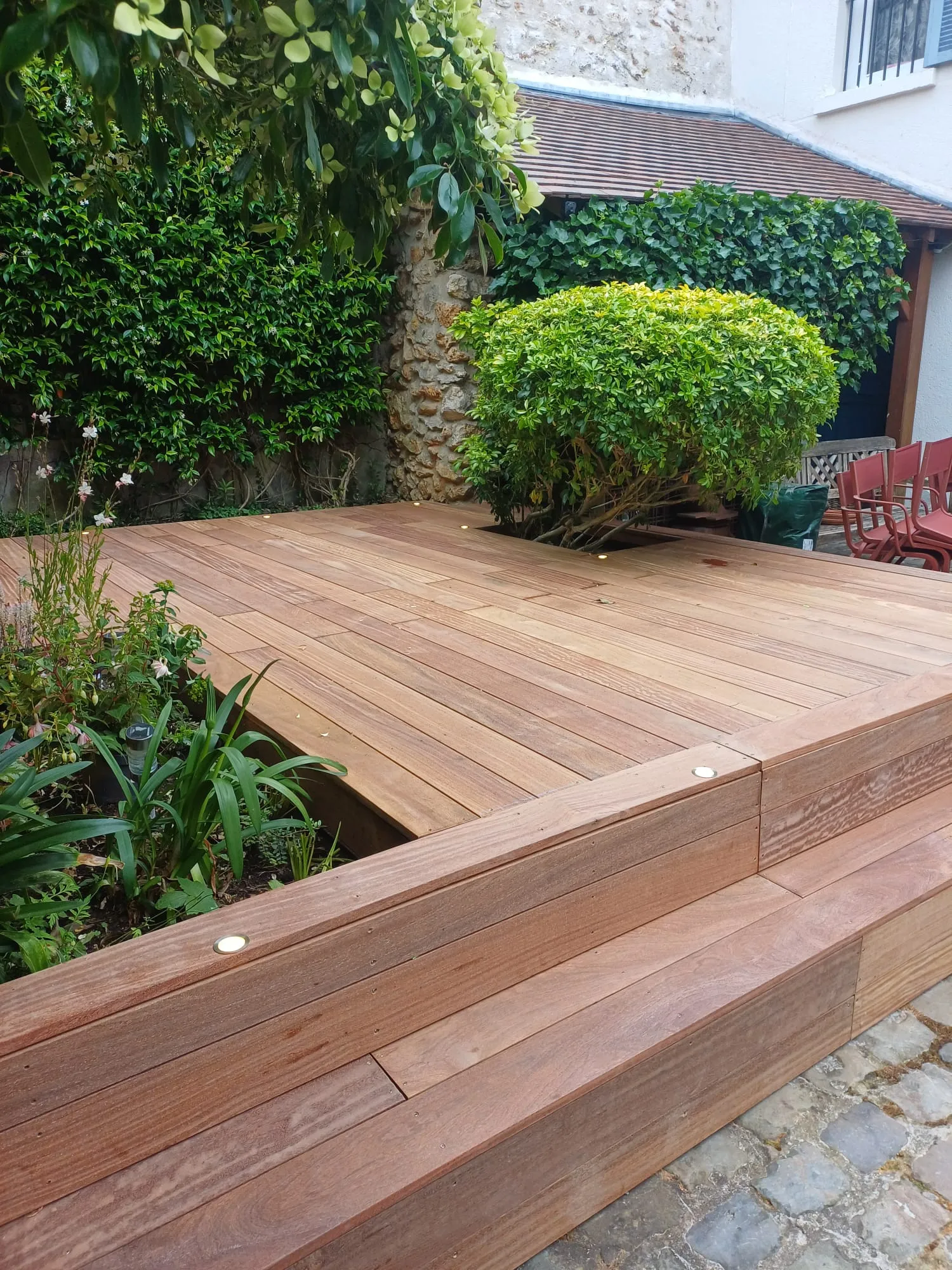 Terrasse bois exotique cumaru avec banc-marche bordé de spots encastrés, à Chambourcy