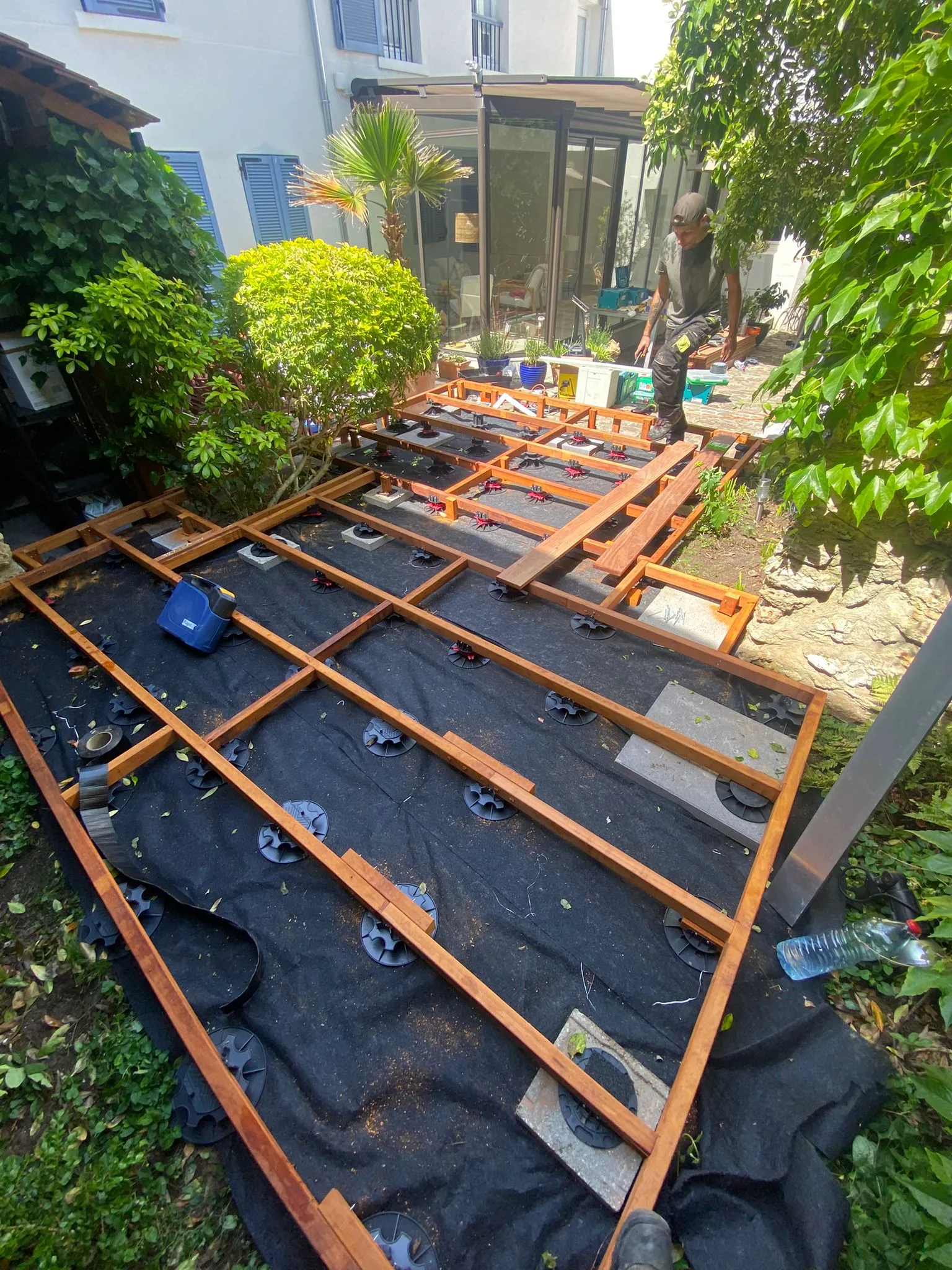 Ossature de terrasse bois sur plots réglables et géotextile avant pose des lames, à Chambourcy