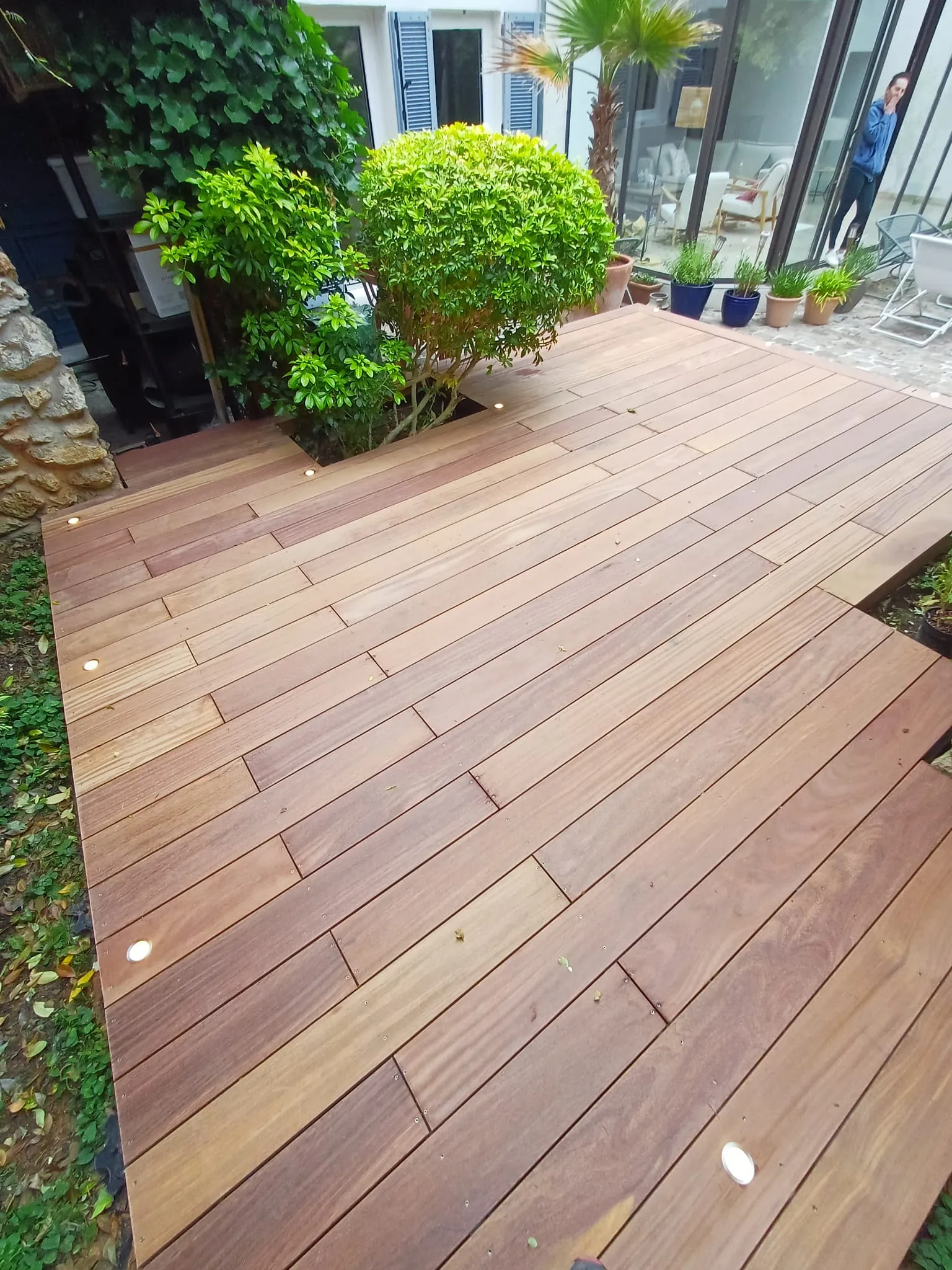 Vue plongeante d'une terrasse bois exotique cumaru autour d'un massif végétal, à Chambourcy