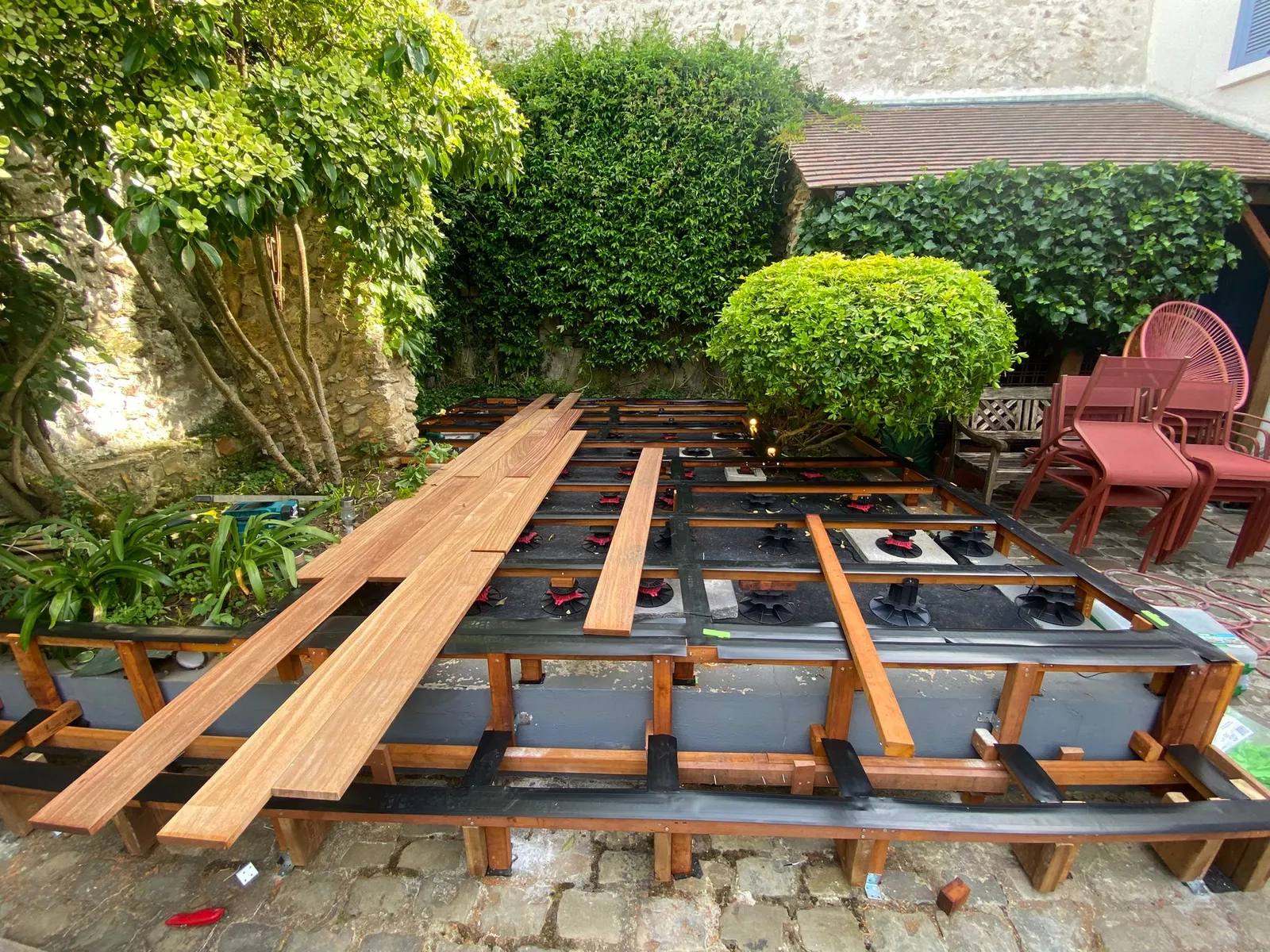 Structure de terrasse bois sur plots réglables avec lambourdes exotiques posées sur géotextile, chantier terrasse La Planète Bois près de Soissons