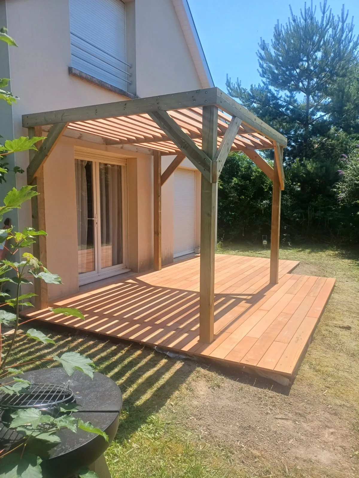 Terrasse en bois exotique et pergola bois adossée en fin de journée, réalisée par La Planète Bois
